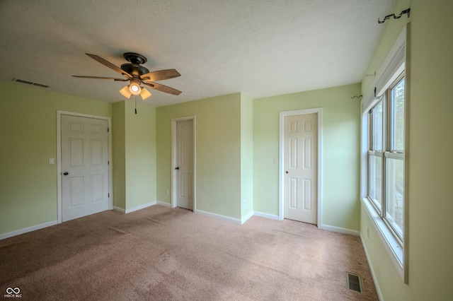 917 Timothy Ct, Bloomington, IN 47403 - unfurnished bedroom with carpet, baseboards, a ceiling fan, and a textured ceiling