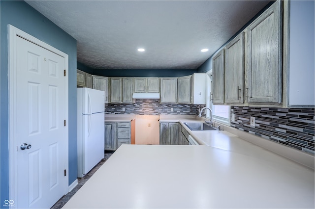 917 Timothy Ct, Bloomington, IN 47403 - kitchen with freestanding refrigerator, a sink, under cabinet range hood, backsplash, and recessed lighting