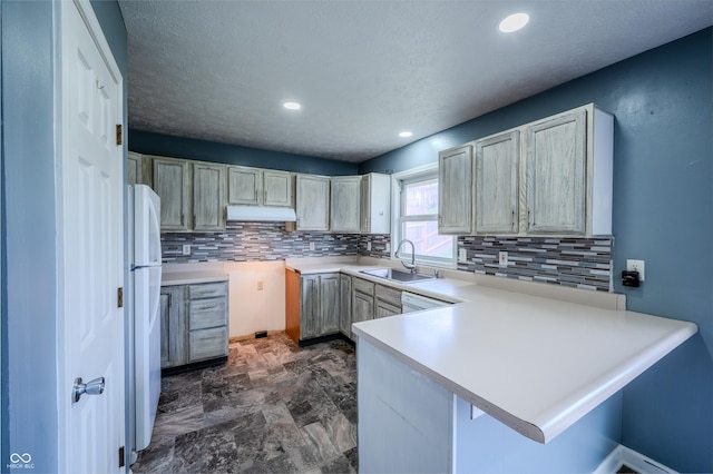917 Timothy Ct, Bloomington, IN 47403 - kitchen featuring a sink, white appliances, a peninsula, tasteful backsplash, and under cabinet range hood
