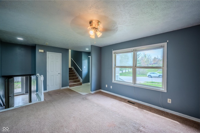 917 Timothy Ct, Bloomington, IN 47403 - carpeted spare room with a ceiling fan, a textured ceiling, stairs, and baseboards
