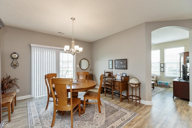 9166 Lieven St, Avon, IN 46123 - dining room with arched walkways, light wood-style floors, a chandelier, and baseboards
