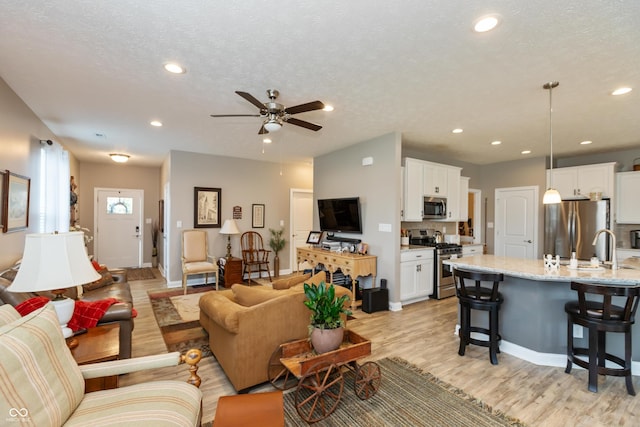 9166 Lieven St, Avon, IN 46123 - living area with light wood-style floors, a ceiling fan, recessed lighting, a textured ceiling, and baseboards