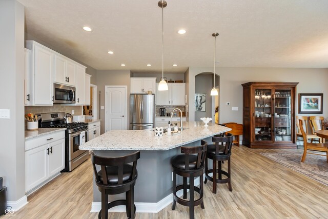 9166 Lieven St, Avon, IN 46123 - kitchen featuring appliances with stainless steel finishes, light wood-style flooring, a sink, backsplash, and white cabinets