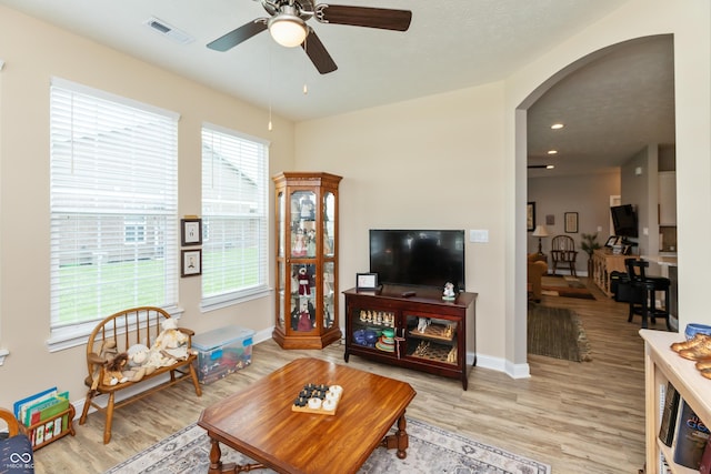 9166 Lieven St, Avon, IN 46123 - living room with arched walkways, light wood-type flooring, ceiling fan, and baseboards