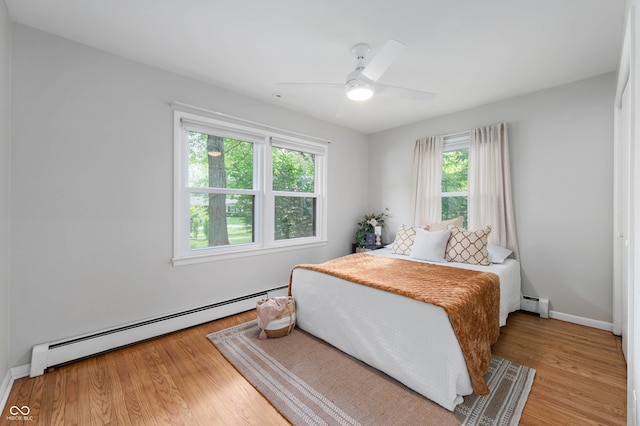 2120 Wynnedale Rd, Indianapolis, IN 46228 - bedroom with a baseboard heating unit, light wood finished floors, and a ceiling fan