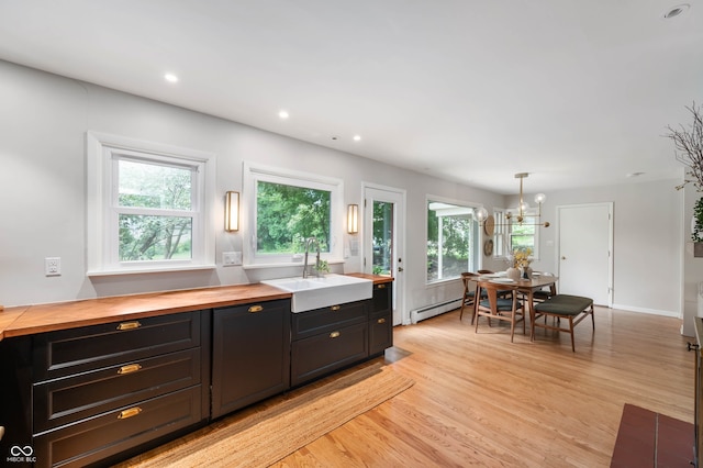 2120 Wynnedale Rd, Indianapolis, IN 46228 - kitchen featuring butcher block counters, light wood-style floors, a baseboard heating unit, recessed lighting, and dark cabinetry