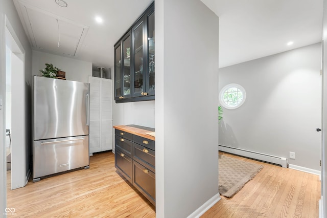 2120 Wynnedale Rd, Indianapolis, IN 46228 - kitchen with freestanding refrigerator, baseboard heating, wooden counters, light wood-style floors, and glass insert cabinets