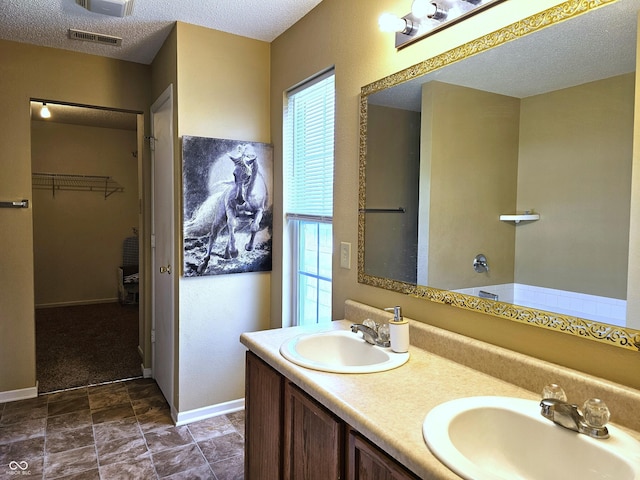 10836 Zimmerman Ln, Indianapolis, IN 46231 - full bath featuring a walk in closet, double vanity, a textured ceiling, and baseboards