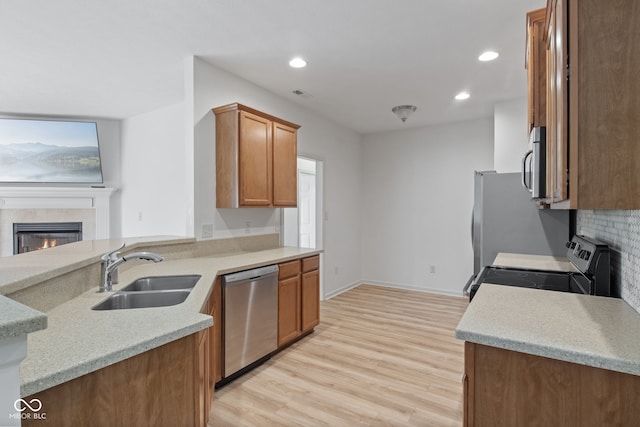 4261 Washington Blvd, Plainfield, IN 46168 - kitchen with appliances with stainless steel finishes, a sink, light wood-style floors, decorative backsplash, and brown cabinets