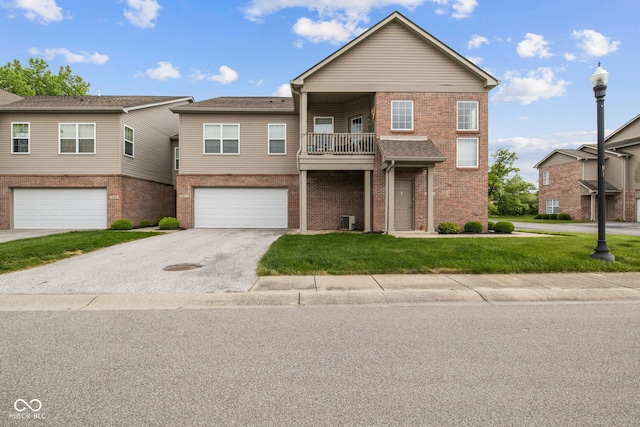 4261 Washington Blvd, Plainfield, IN 46168 - view of front facade with brick siding, a front yard, a balcony, a garage, and asphalt driveway