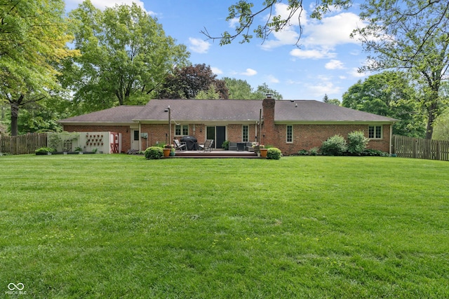 rear view of house featuring a wooden deck, brick siding, and a chimney