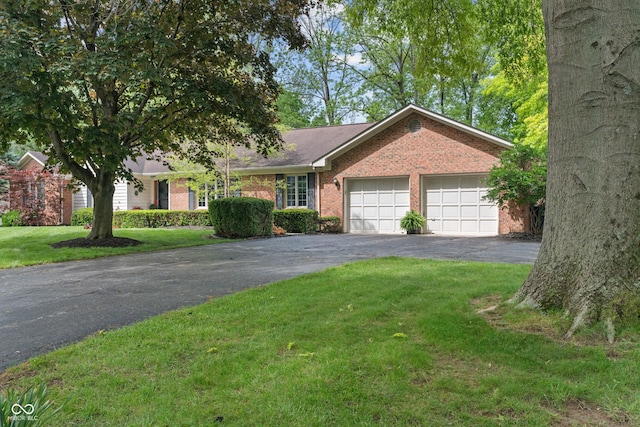 ranch-style house featuring driveway, brick siding, an attached garage, and a front yard