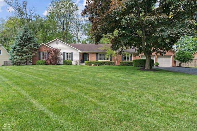 ranch-style home with brick siding, driveway, an attached garage, and a front yard