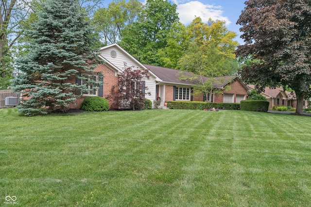 ranch-style house with brick siding, an attached garage, a front yard, and central air condition unit
