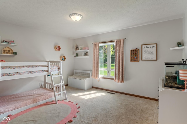 bedroom with carpet flooring, baseboards, and a textured ceiling