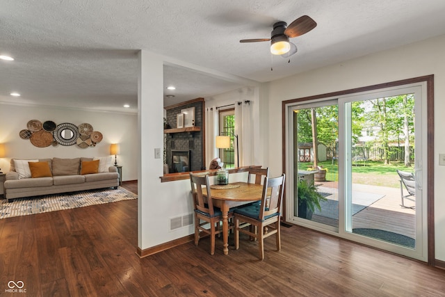 dining room featuring wood finished floors, plenty of natural light, a ceiling fan, a textured ceiling, and recessed lighting