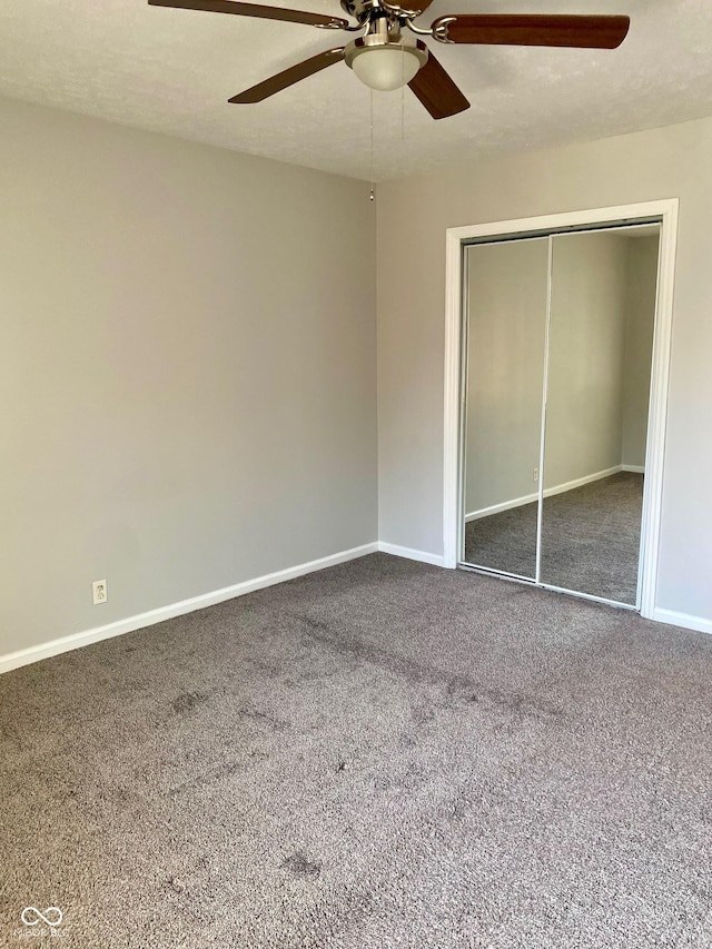 1150 Canterbury Ct Apt D, Indianapolis, IN 46260 - unfurnished bedroom with dark carpet, baseboards, a closet, and ceiling fan