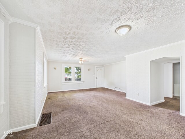 903 W 22nd St, Anderson, IN 46016 - empty room featuring carpet, ornamental molding, baseboards, brick wall, and a textured ceiling