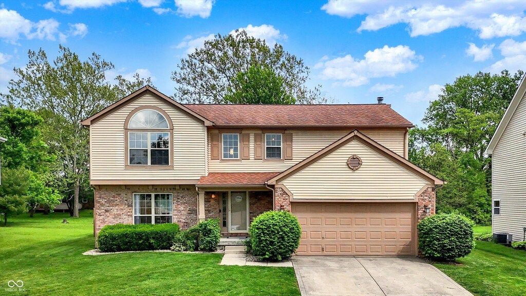 6609 Fountain Springs Blvd, Indianapolis, IN 46236 - traditional home with central AC, brick siding, driveway, and a front lawn