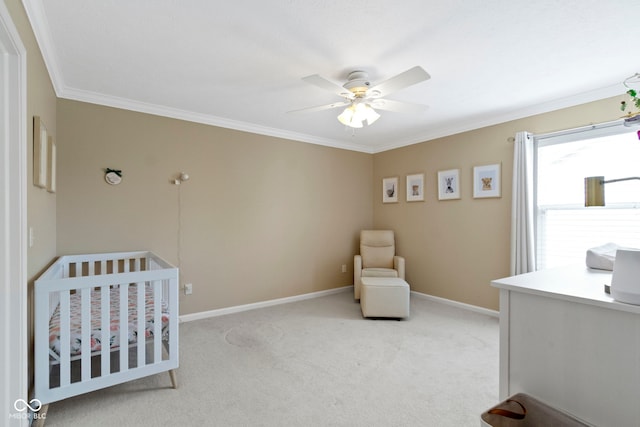 bedroom with a crib, light carpet, crown molding, and baseboards
