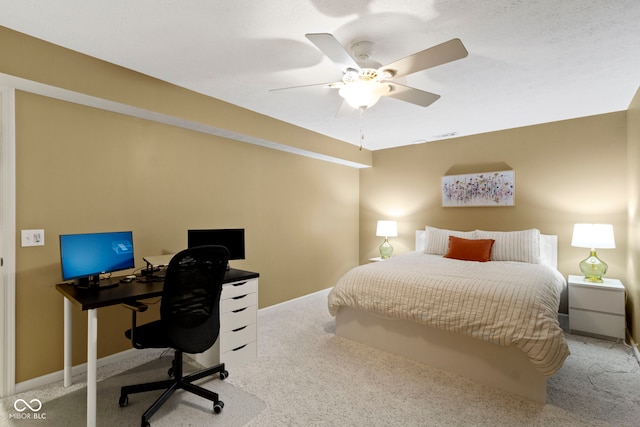 carpeted bedroom featuring a desk, a ceiling fan, and baseboards
