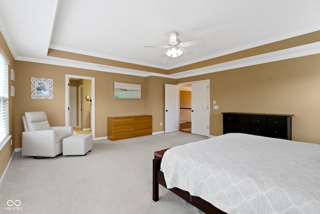 bedroom with ornamental molding, carpet, baseboards, a tray ceiling, and a ceiling fan