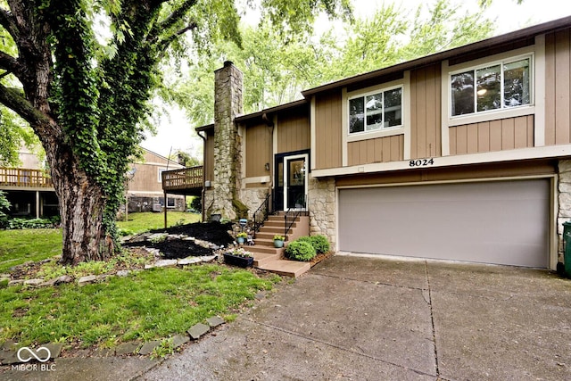 8024 Sunfield Ct Unit 5-B, Indianapolis, IN 46214 - split foyer home with a garage, a chimney, concrete driveway, and stone siding