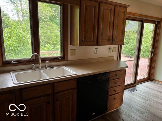310 S Shady Ln, Muncie, IN 47304 - kitchen with black dishwasher, a sink, healthy amount of natural light, and light wood-type flooring