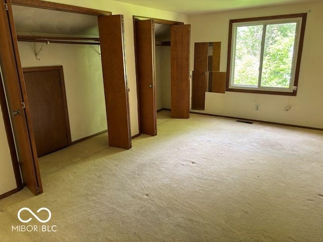 310 S Shady Ln, Muncie, IN 47304 - unfurnished bedroom with two closets, light colored carpet, and baseboards