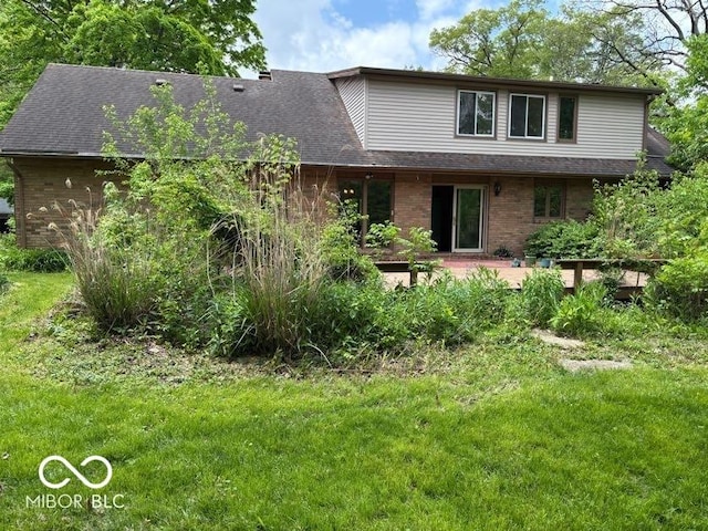 310 S Shady Ln, Muncie, IN 47304 - back of property with brick siding, a lawn, a patio area, and roof with shingles