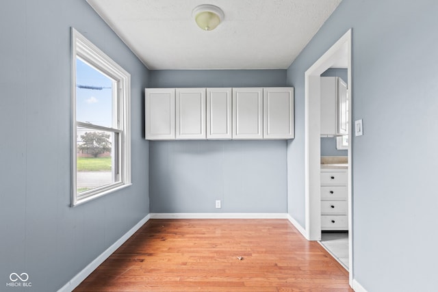 703 Kappes St, Indianapolis, IN 46221 - empty room featuring light wood-style floors, baseboards, and a textured ceiling