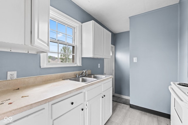 703 Kappes St, Indianapolis, IN 46221 - kitchen featuring a sink, electric range, white cabinetry, light countertops, and baseboards