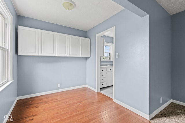 703 Kappes St, Indianapolis, IN 46221 - spare room with baseboards, light wood-style floors, and a textured ceiling
