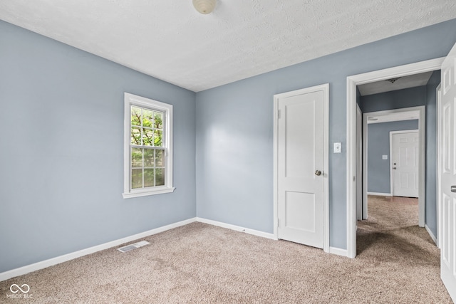 703 Kappes St, Indianapolis, IN 46221 - unfurnished bedroom featuring carpet, baseboards, and a textured ceiling
