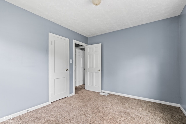 703 Kappes St, Indianapolis, IN 46221 - unfurnished bedroom with carpet floors, baseboards, and a textured ceiling