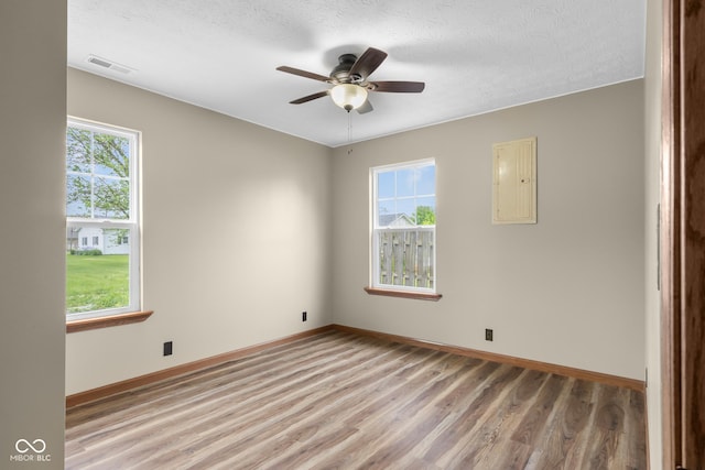 632 W Central Ave, Greensburg, IN 47240 - empty room with light wood-style flooring, electric panel, baseboards, ceiling fan, and a textured ceiling