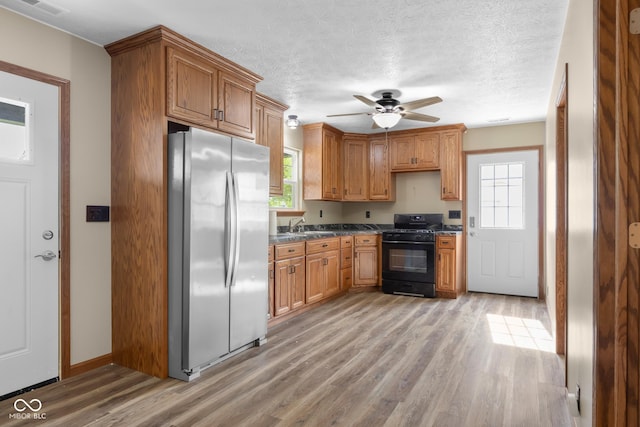 632 W Central Ave, Greensburg, IN 47240 - kitchen featuring black range with gas cooktop, freestanding refrigerator, dark countertops, light wood-style floors, and a textured ceiling
