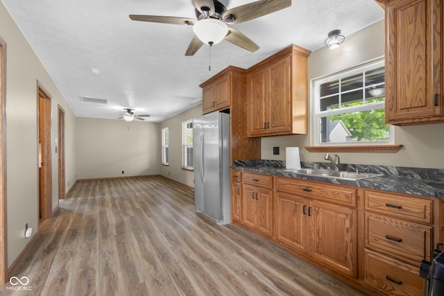 632 W Central Ave, Greensburg, IN 47240 - kitchen featuring freestanding refrigerator, a sink, a ceiling fan, brown cabinetry, and light wood-style flooring