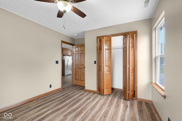 632 W Central Ave, Greensburg, IN 47240 - unfurnished bedroom featuring freestanding refrigerator, light wood-type flooring, baseboards, a closet, and a ceiling fan