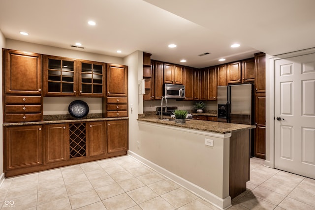 8690 Jaffa Ct W Drive 28, Indianapolis, IN 46260 - kitchen with open shelves, appliances with stainless steel finishes, light tile patterned floors, dark stone counters, and a peninsula