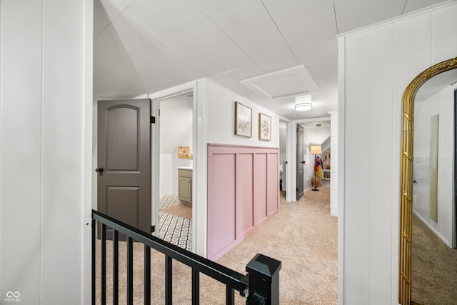 corridor with carpet flooring and attic access