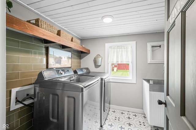 laundry area featuring baseboards, separate washer and dryer, wooden ceiling, and light tile patterned flooring