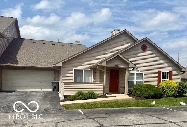 3016 Wildcat Ln, Indianapolis, IN 46203 - view of front facade featuring an attached garage, a chimney, and asphalt driveway