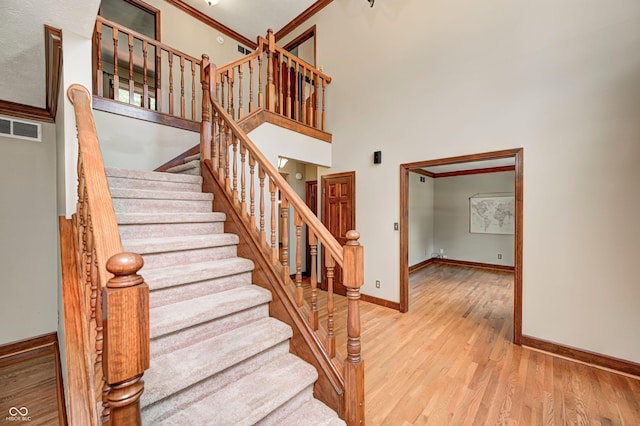 9158 Oak Knoll Ln, Fishers, IN 46037 - stairs featuring wood finished floors, a towering ceiling, and ornamental molding