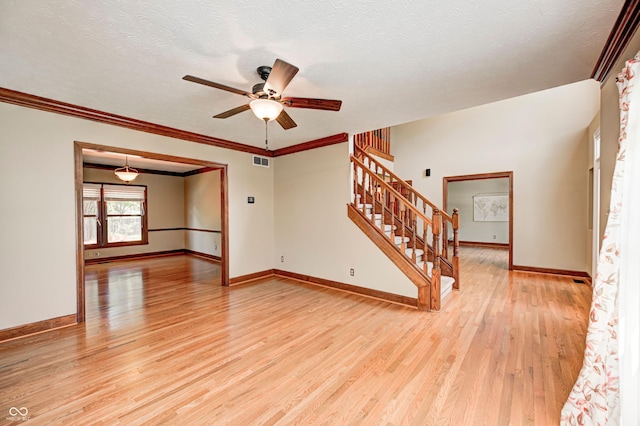 9158 Oak Knoll Ln, Fishers, IN 46037 - empty room with light wood-style floors, stairway, a ceiling fan, ornamental molding, and a textured ceiling