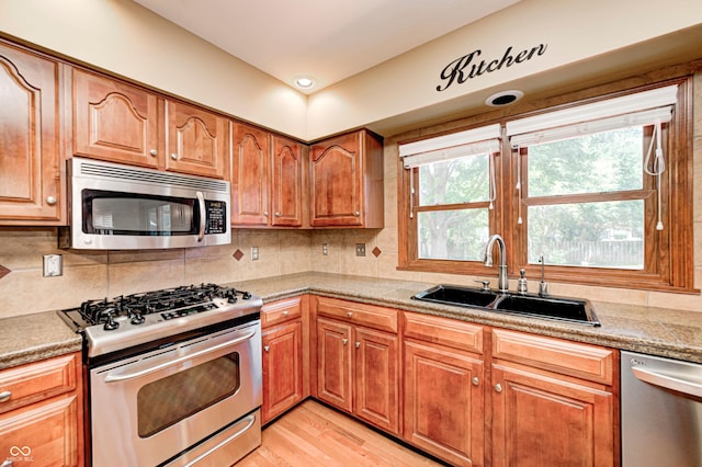 9158 Oak Knoll Ln, Fishers, IN 46037 - kitchen featuring stainless steel appliances, tasteful backsplash, brown cabinets, and light wood-style floors