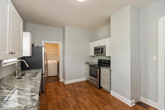 1661 S Talbott St, Indianapolis, IN 46225 - kitchen featuring appliances with stainless steel finishes, washer / clothes dryer, dark wood finished floors, and baseboards
