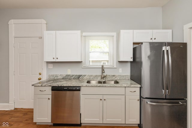 1661 S Talbott St, Indianapolis, IN 46225 - kitchen featuring appliances with stainless steel finishes, a sink, white cabinetry, and wood finished floors