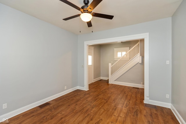 1661 S Talbott St, Indianapolis, IN 46225 - empty room with ceiling fan, baseboards, wood finished floors, and stairway