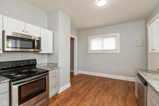 1661 S Talbott St, Indianapolis, IN 46225 - kitchen with appliances with stainless steel finishes, baseboards, light wood-style floors, white cabinets, and light stone countertops